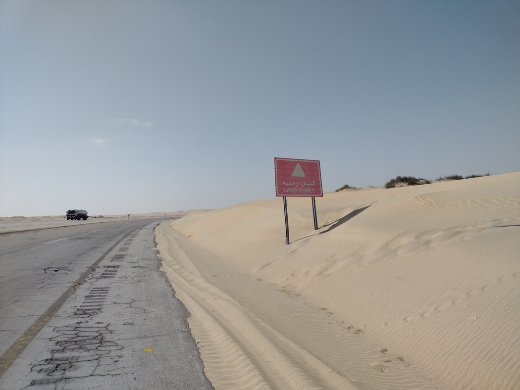 Schild, das vor Sand-Dünen warnt