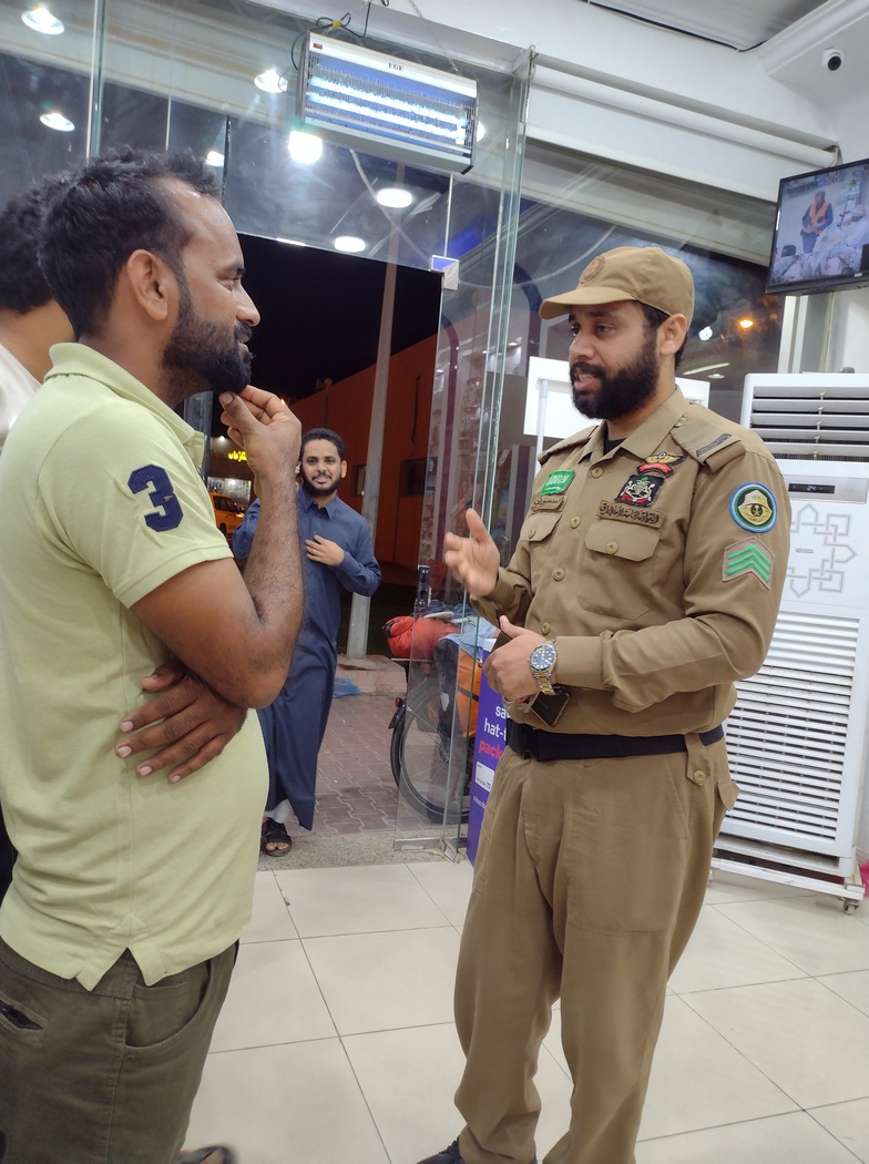 Polizist unterhält sich mit Männern in einem Handy-Laden