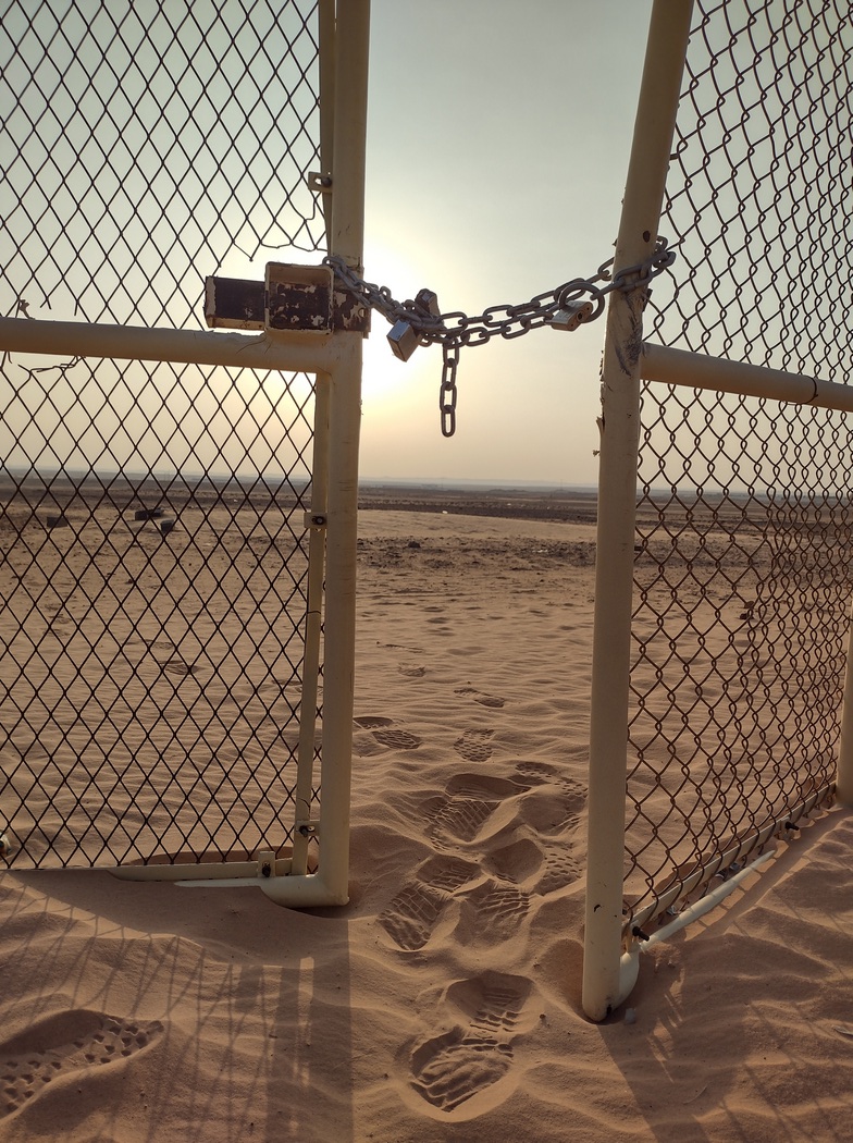 Verschlossenes Tor mit großer Lücke, um hindurchzuschlüpfen