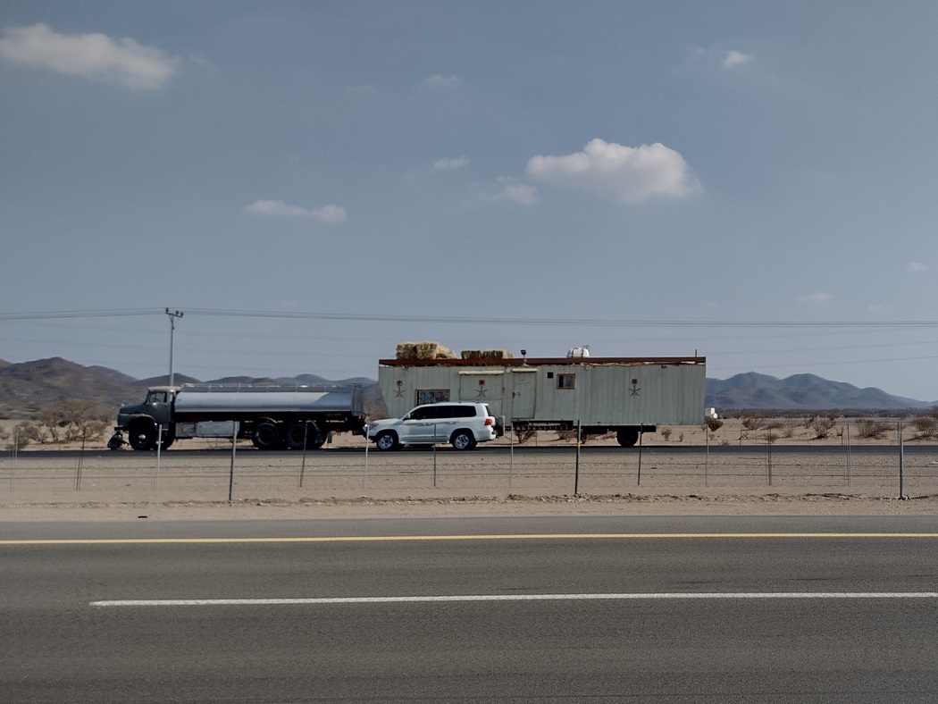 Typisches Fahrzeug von Nomaden: Tanklaster voll mit Wasser zieht Blechhaus, Strohballen auf dem Dach für die Kamele