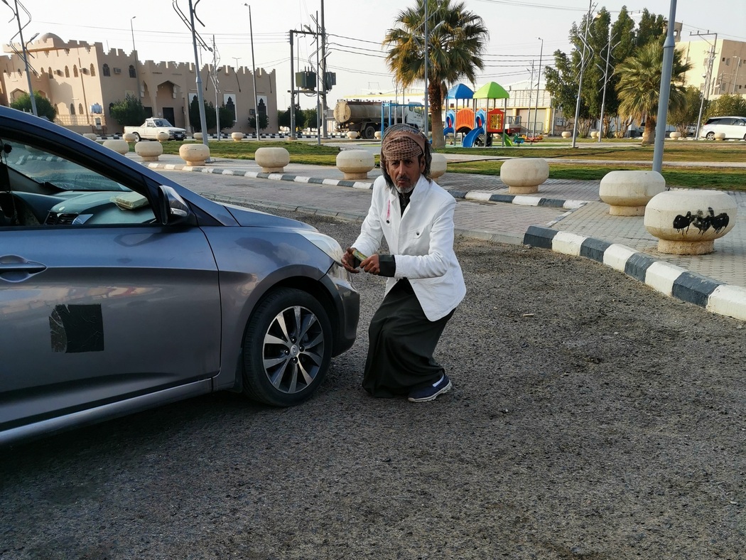 Mann tanzt um sein Auto