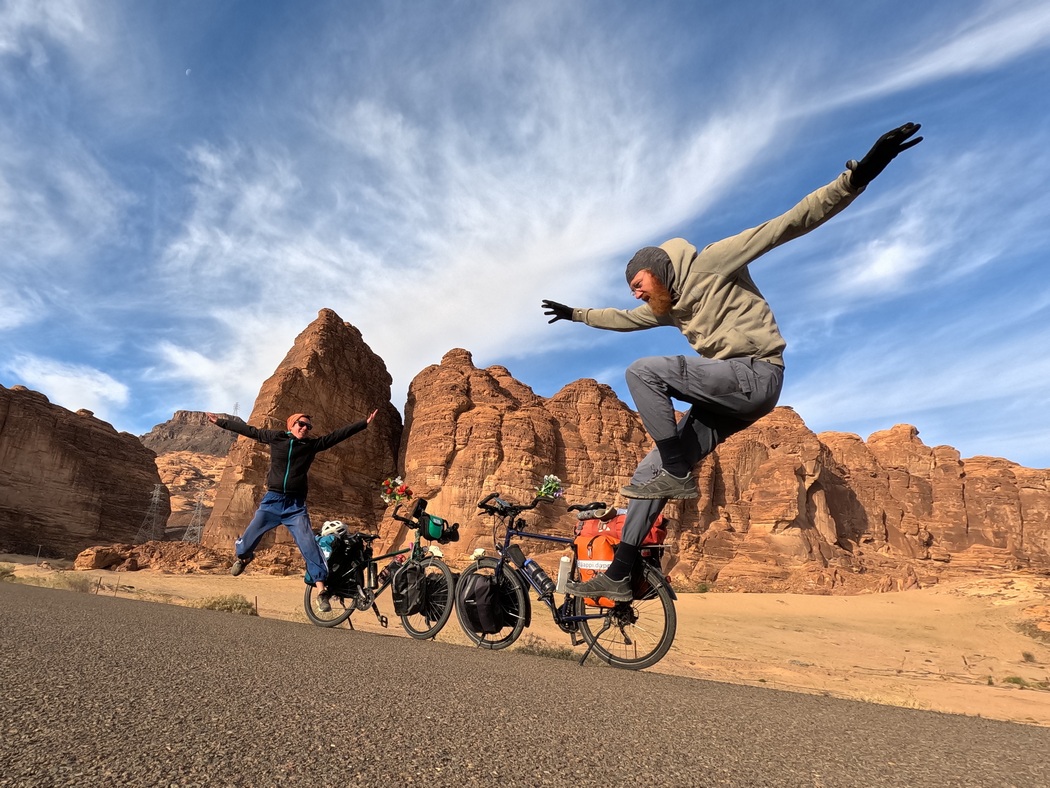 Julia und Tilmann springen vor Fahrrädern und vor Felsen