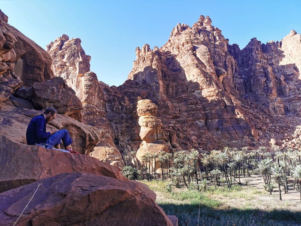 Tilmann sitzt auf Felsvorsprung über dem Wadi