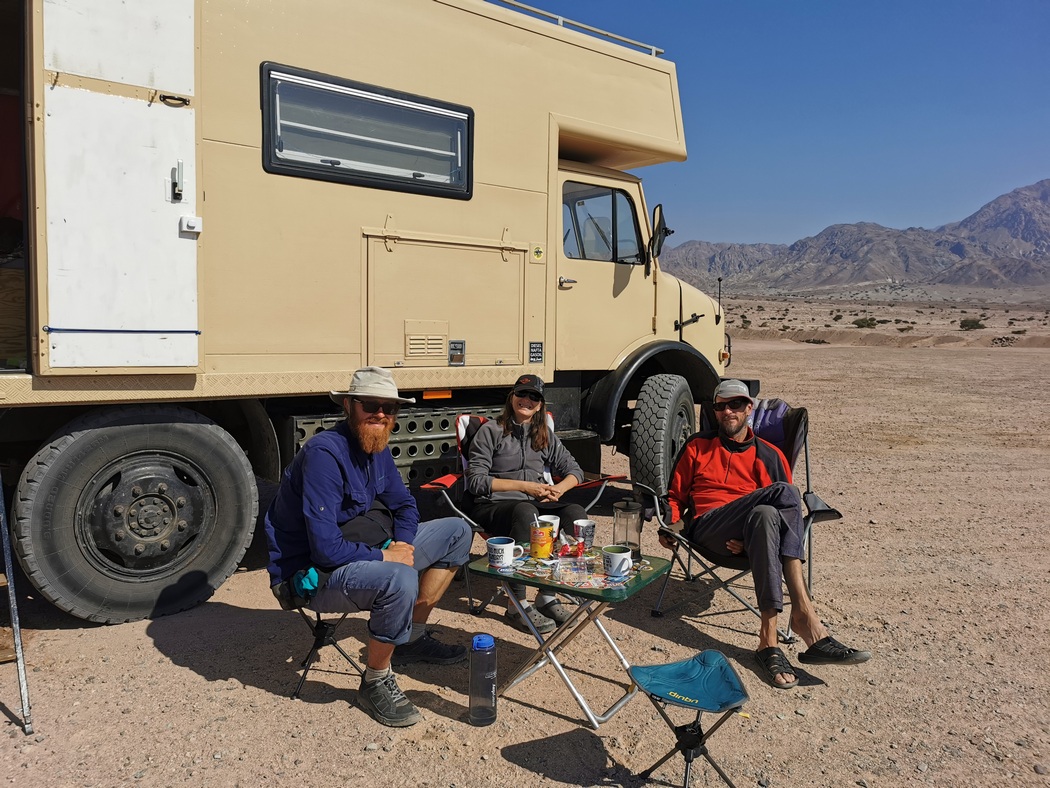 Tilmann sitzt mit Andi und Claudia vor Reisetruck