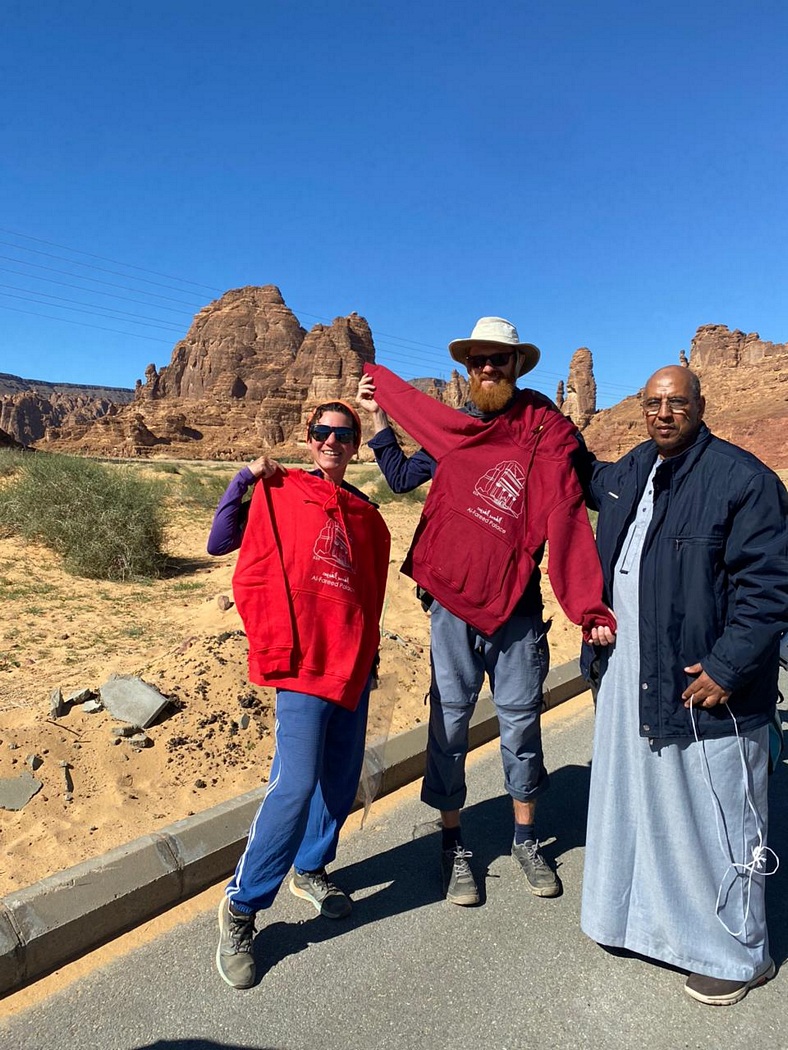 Julia, Tilmann und ein Mann halten Pullis hoch