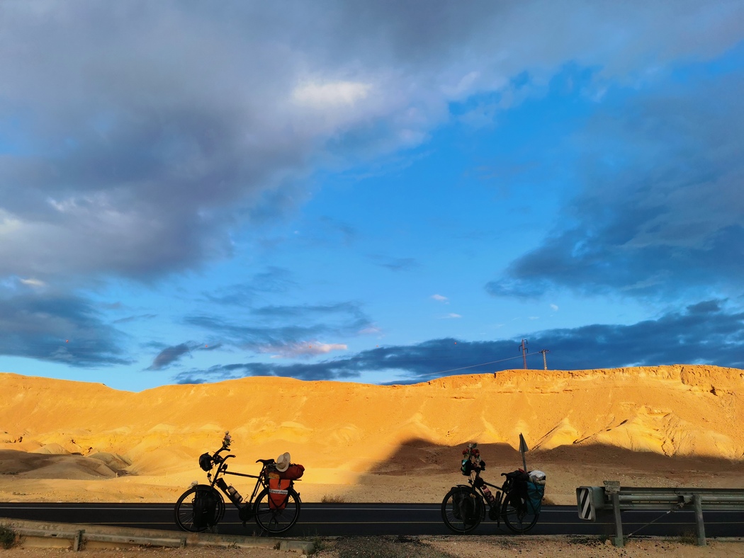 Fahrräder vor gelben Berg, dahinter blauer Himmel